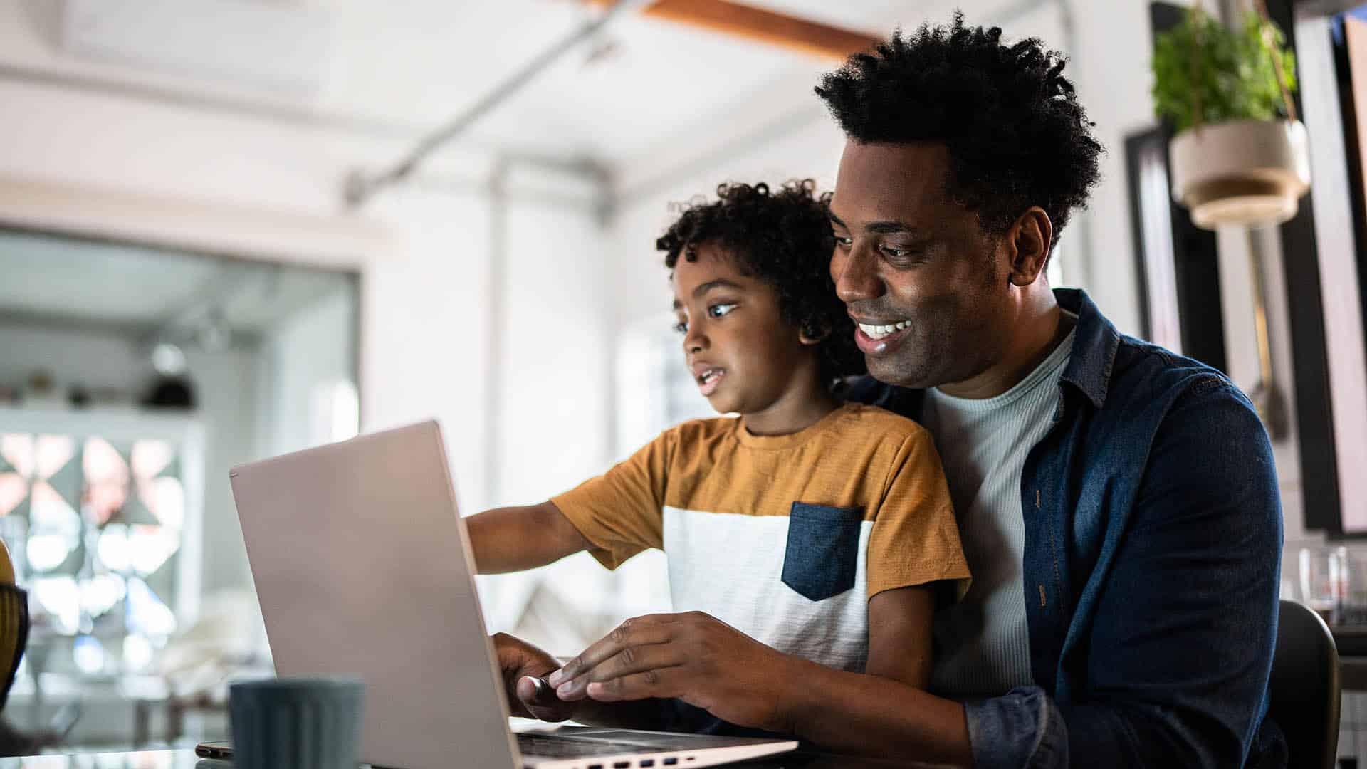 Father and child using the laptop at home